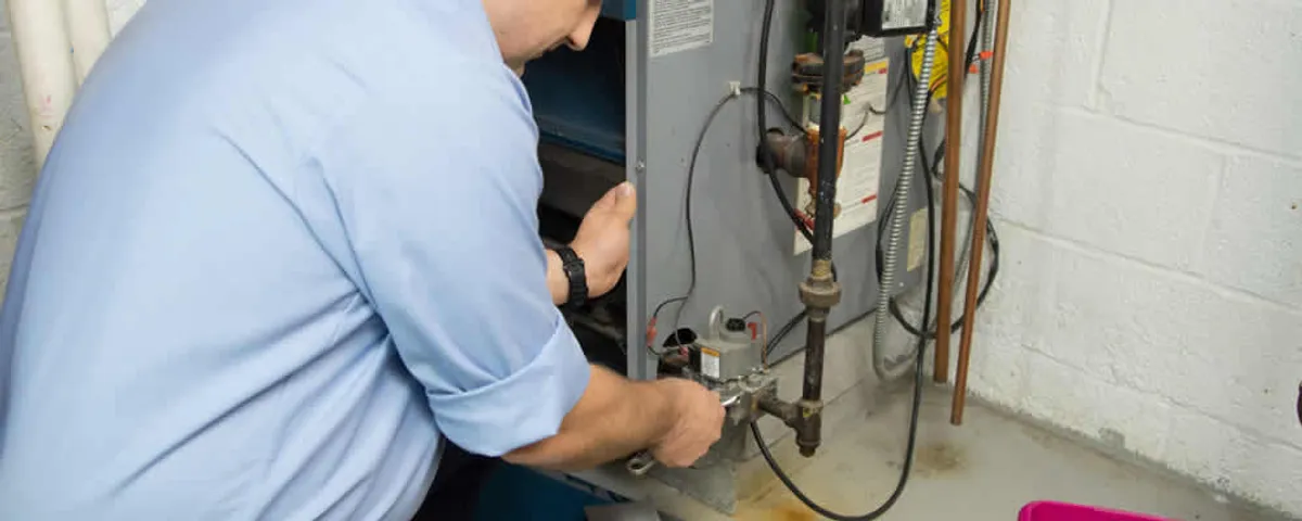 Furnace repair technician inspecting and servicing a home heating system in Burlington, MA