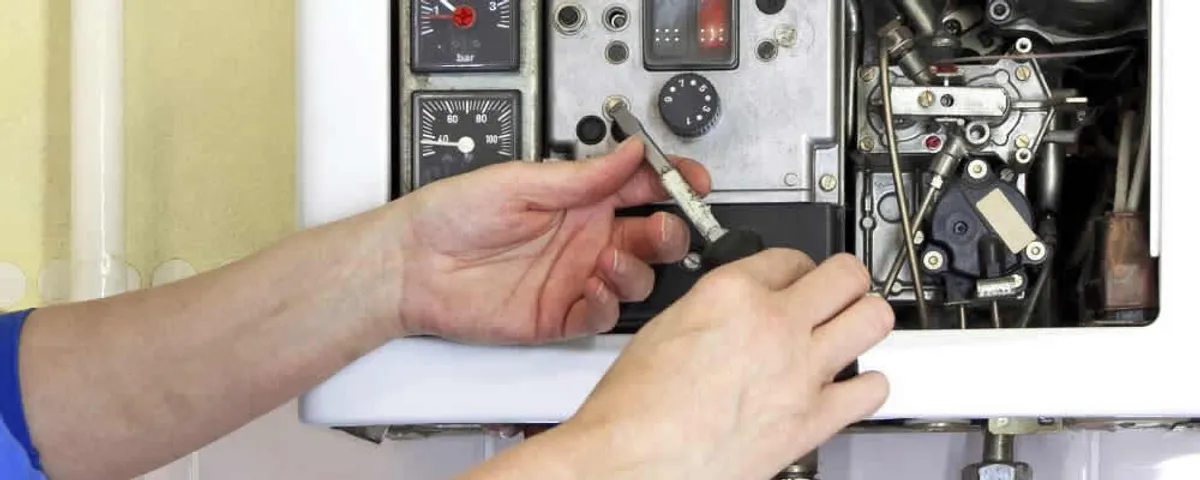 Heating repair technician adjusting boiler controls and components in Burlington, MA