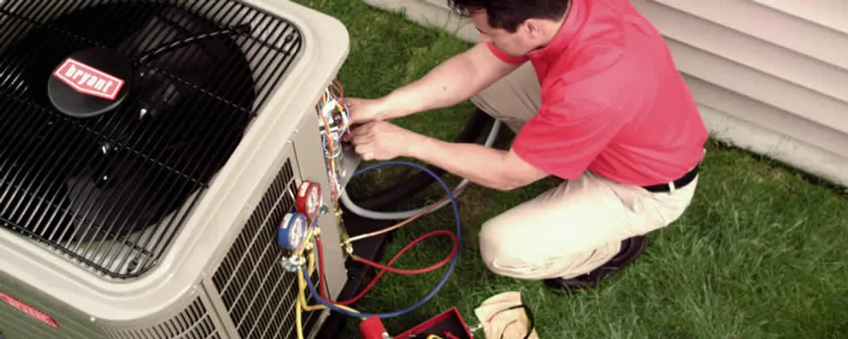 HVAC technician servicing an outdoor air conditioner unit in Burlington, MA