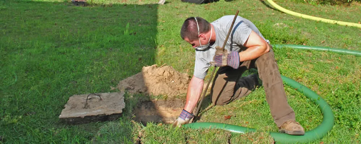 Septic pumping technician servicing a residential septic tank in Burlington, MA